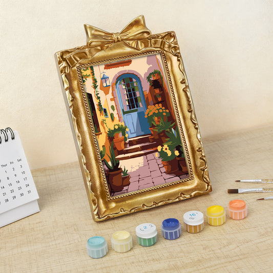 Framed mini paint by numbers of a charming garden door surrounded by lush flowers and greenery